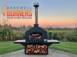 Cooking on a New Zealand-made Bakewell outdoor fireplace oven in front of a pink setting sky surrounded by vineyards and rolling hills in beautiful Sonoma County
