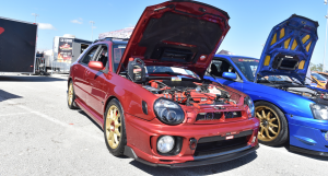 a Red WRX wagon that is featured in front of the TR Motul booth