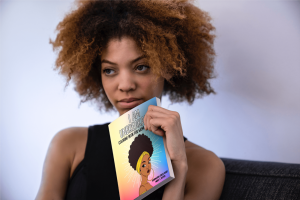 Black woman holds WOC Adult Affirmation Coloring Book
