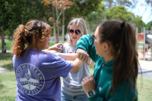 Photo of three women being taught self-defense. LATLC proudly sponsored a highly successful women's empowerment event, activities included a self-defense class.